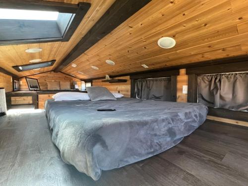 un grande letto in una camera con soffitto in legno di Garden Village Tiny Homes a Hildale