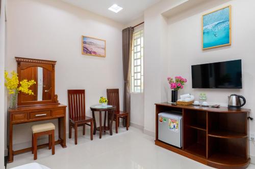 a living room with a desk and a tv at Queen Garden Hotel & Apartment in Vung Tau
