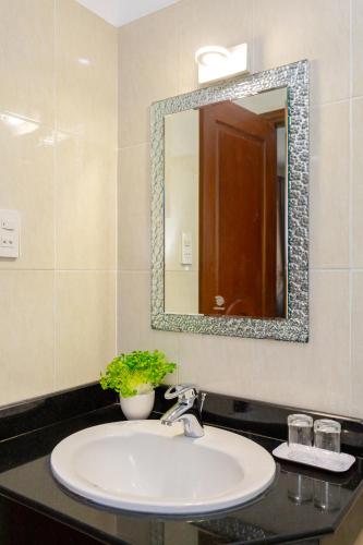 a bathroom with a sink and a mirror at Queen Garden Hotel & Apartment in Vung Tau