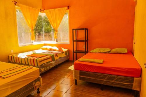 Cette chambre comprend 2 lits et une fenêtre. dans l'établissement Casa grande Monterrico, à Monterrico