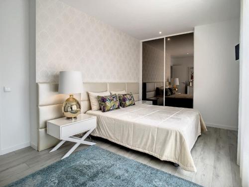 a bedroom with a large bed and a mirror at Rancho Tá-Mar Apartment Nazaré Beach in Nazaré