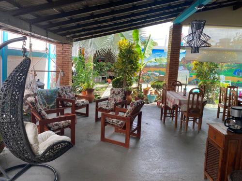 een patio met stoelen, een tafel en een hangmat bij Pousada das Flores. in Boa Vista