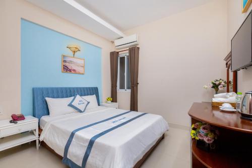 a bedroom with a bed with a blue and white comforter at Queen Garden Hotel & Apartment in Vung Tau