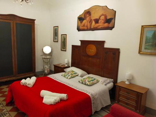 - une chambre avec un lit rouge et 2 oreillers dans l'établissement Casa in palazzo Graffeo Sven, à Palerme