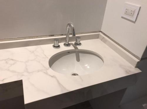 a bathroom sink with a white marble counter top at Departamento Moderno en el centro con pileta in San Miguel de Tucumán