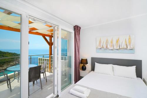 a bedroom with a bed and a balcony with a view at Villa Irene in Skala Marion