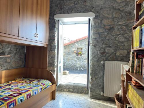 的住宿－Casa nel borgo - A Rigadèa，一间卧室设有一张床和石墙