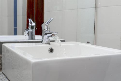 a white sink with water coming out of it at Taste of Mexico Hostel in Dar es Salaam