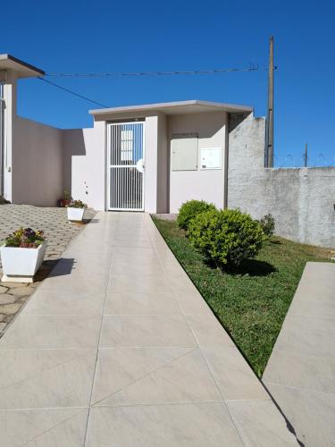 une passerelle en béton devant une maison dans l'établissement Residencial Melodia, à Campos Novos