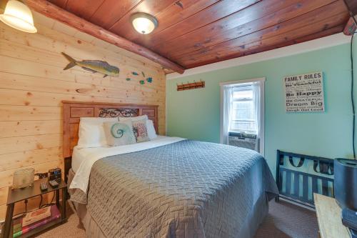 um quarto com uma cama num chalé de madeira em Cozy Houghton Lake Vacation Rental with Fireplace! em Houghton Lake