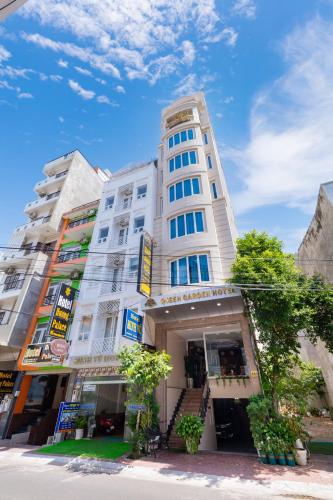 a tall white building on a city street at Queen Garden Hotel & Apartment in Vung Tau