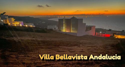 a sunset over the ocean with white buildings on a hill at Master Suite in Bellavista Andalucia with Pool and Beach in Al Matlīn