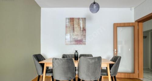 a dining room with a wooden table and gray chairs at Konfor home in Istanbul