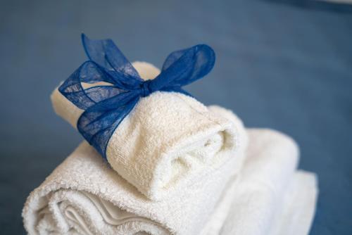 ein weißes Handtuch mit blauem Bogen drauf. in der Unterkunft Antonia Jess Central ,Near Beach- by Gessica homes in Monopoli