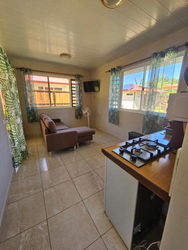 eine Küche und ein Wohnzimmer mit einem Herd mit Backofen in der Unterkunft Miki Miki Surf Lodge in Moorea