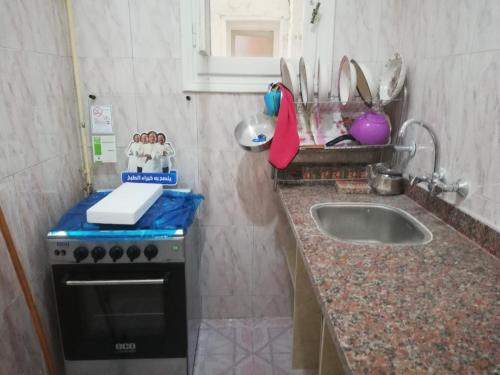 uma pequena cozinha com um fogão e um lavatório em شقة فاخرة بالغردقة em Hurghada
