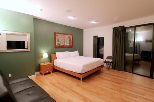 een slaapkamer met een bed en een bank bij Luxurious Hillside Home Wac & Gorgeous Sf Views! in Oakland