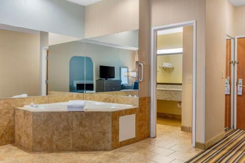 a large bathroom with a tub and a television at Best Western Plus New England Inn & Suites in Berlin