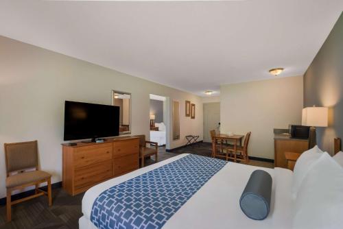 a hotel room with a bed and a flat screen tv at SureStay Plus Hotel by Best Western Berkeley Springs in Berkeley Springs