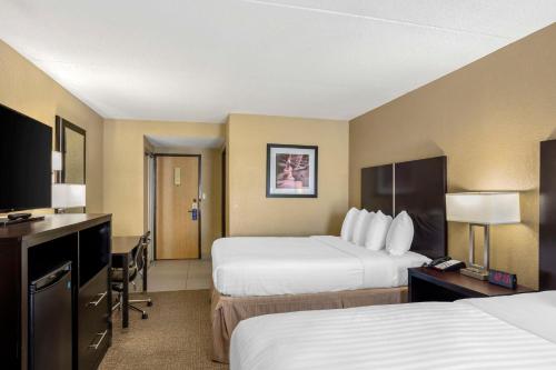 a hotel room with two beds and a television at Best Western Harrisburg North Hotel in Harrisburg