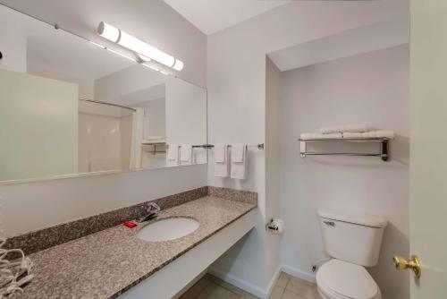 a bathroom with a sink and a toilet and a mirror at SureStay Plus Hotel by Best Western Berkeley Springs in Berkeley Springs