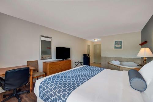 a hotel room with a bed and a desk and a television at SureStay Plus Hotel by Best Western Berkeley Springs in Berkeley Springs