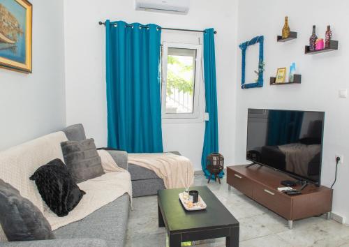 a living room with a couch and a tv at (Stoa escape) traditional home in Archangelos