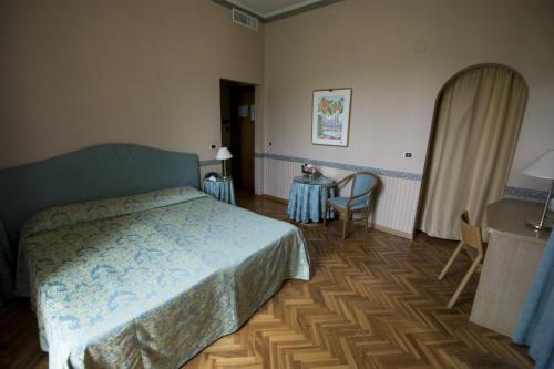 a bedroom with a bed and a table and chairs at Hotel Giglio in Montecatini Terme