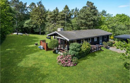 a small house in a yard with flowers and plants at Nice Home In Fårevejle With Wifi in Fårevejle