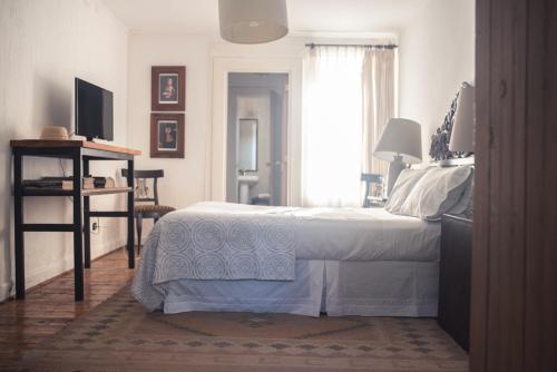 a bedroom with a white bed and a window at Cruz de Triana in Rancagua