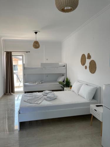 a white bedroom with a large bed in a room at Athena's Studios 2 in Polykhrono