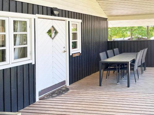 a wooden deck with a table and chairs and a door at 6 person holiday home in Glesborg-By Traum in Glesborg