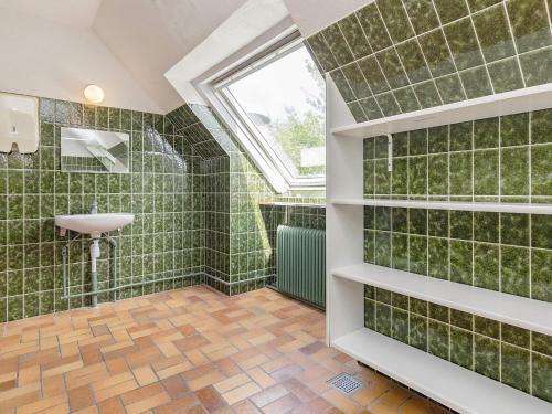 La salle de bains est pourvue de murs carrelés verts et d'une fenêtre. dans l'établissement Fourteen-Bedroom Holiday home in Hurup Thy, à Sindrup