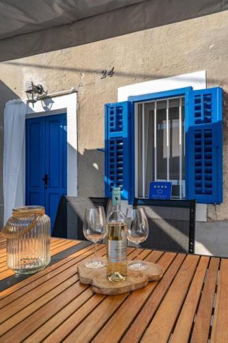 a wooden table with two glasses and a bottle of wine at House Franulich in Stara Baška