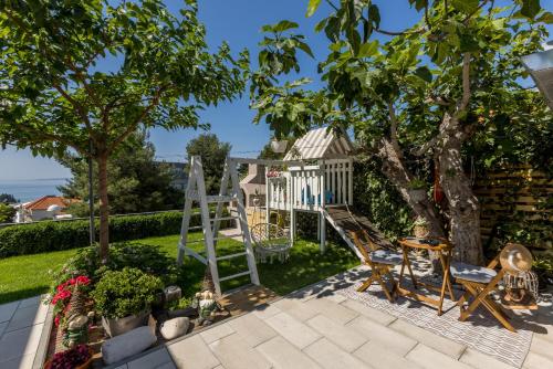 a garden with a playground and a gazebo at Villa KaTess with heated pool in Split