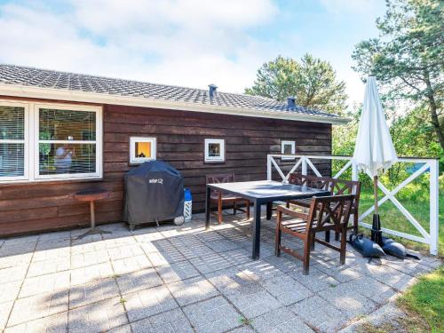 un patio con mesa y sillas frente a una casa en 6 person holiday home in L gst r, en Trend