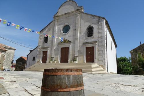 an old church with a banner in front of it at Villa Letizia in Oprtalj