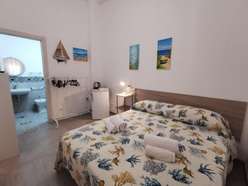 a bedroom with a bed and a bathroom at SOLE MIO Vacation in San Vito lo Capo