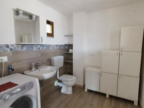 a bathroom with a toilet and a sink and a washing machine at SOLE MIO Vacation in San Vito lo Capo