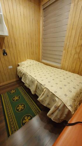 a small bed in a room with a window at El Capitán in Puerto Montt