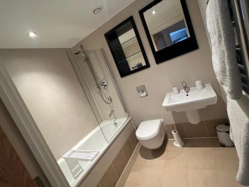 a bathroom with a shower toilet and a sink at Sugarhill Leeds docks in Leeds