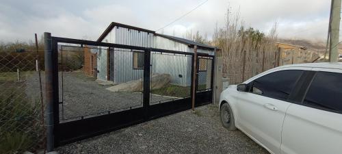 una puerta con un coche estacionado junto a una valla en Mia cabañas en El Calafate
