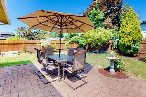a table and chairs with an umbrella on a patio at Casa Dundee in Dundee
