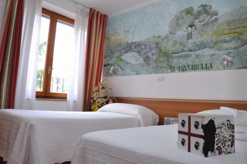 una camera d'albergo con due letti e un dipinto sul muro di Sale Hotel a Posada