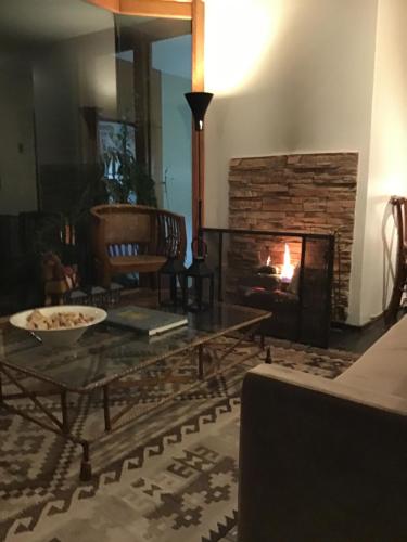 a living room with a fireplace and a table at Rent apart Las Condes in Santiago
