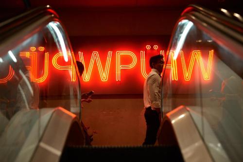 a man standing in front of a neon sign at WPU Shinjuku in Tokyo