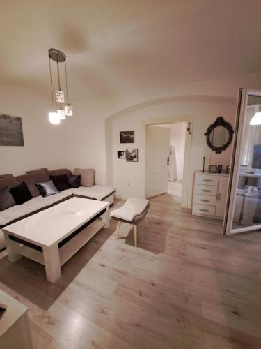 ein Wohnzimmer mit einem Sofa und einem Tisch in der Unterkunft Apartment Skenderija Pet friendly with garden in Sarajevo