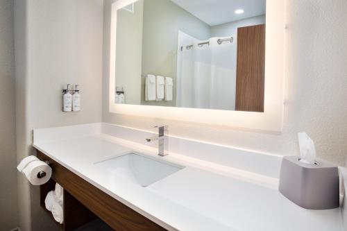 a white bathroom with a sink and a mirror at Holiday Inn Express Hotel and Suites Katy by IHG in Katy