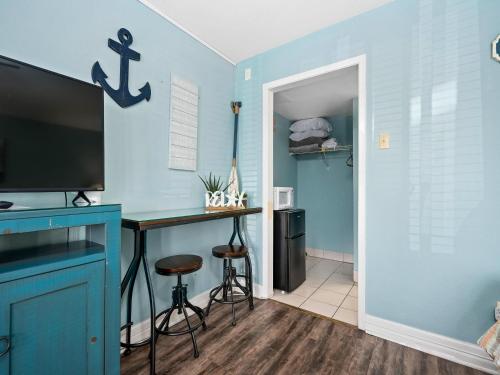 a room with a desk with a tv and a blue wall at Laguna Reef #119 - Simpatico in Rockport