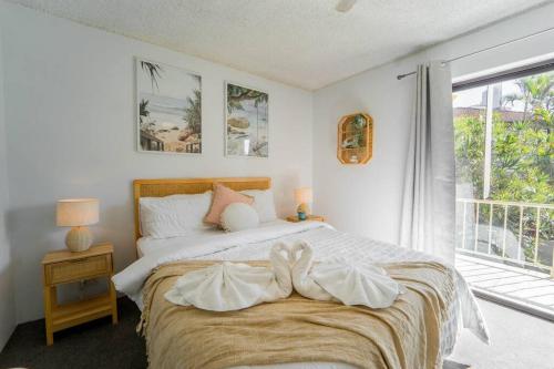 a bedroom with a large bed and a window at Quiet Family Apartment Near Beach with Pool in Gold Coast